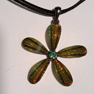 green and yellow glitter flower pendant on a black necklace